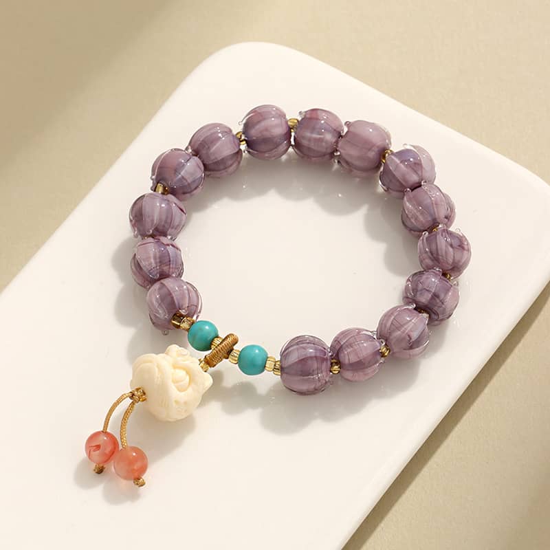 Purple gemstone self-care bracelet featuring beads and a decorative charm for stress relief