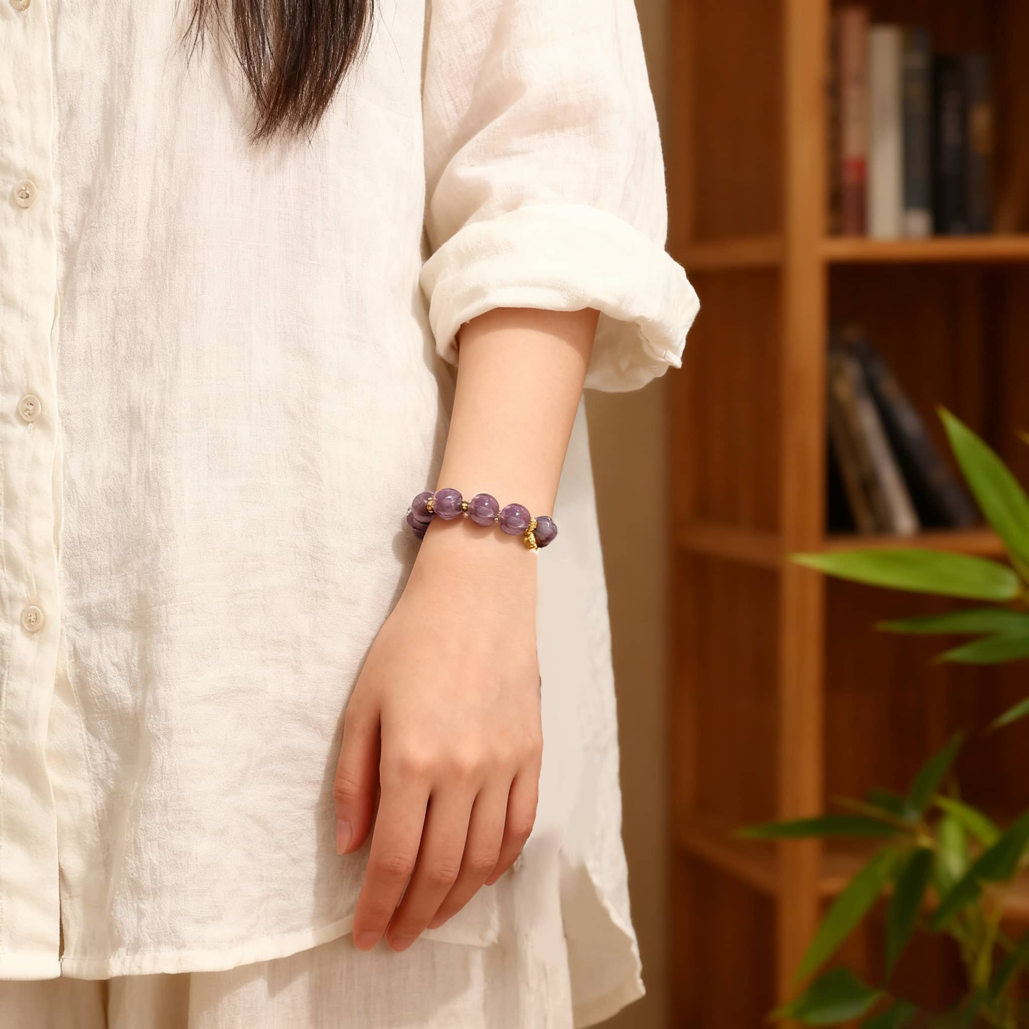 Purple gemstone self-care bracelet displayed on a person's wrist with a minimalist outfit