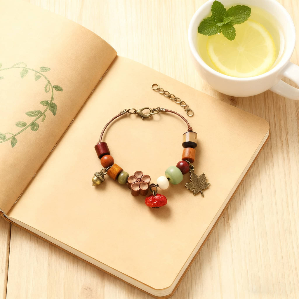 Colorful red berry wood bead bracelet with floral and leaf charms on a wooden surface