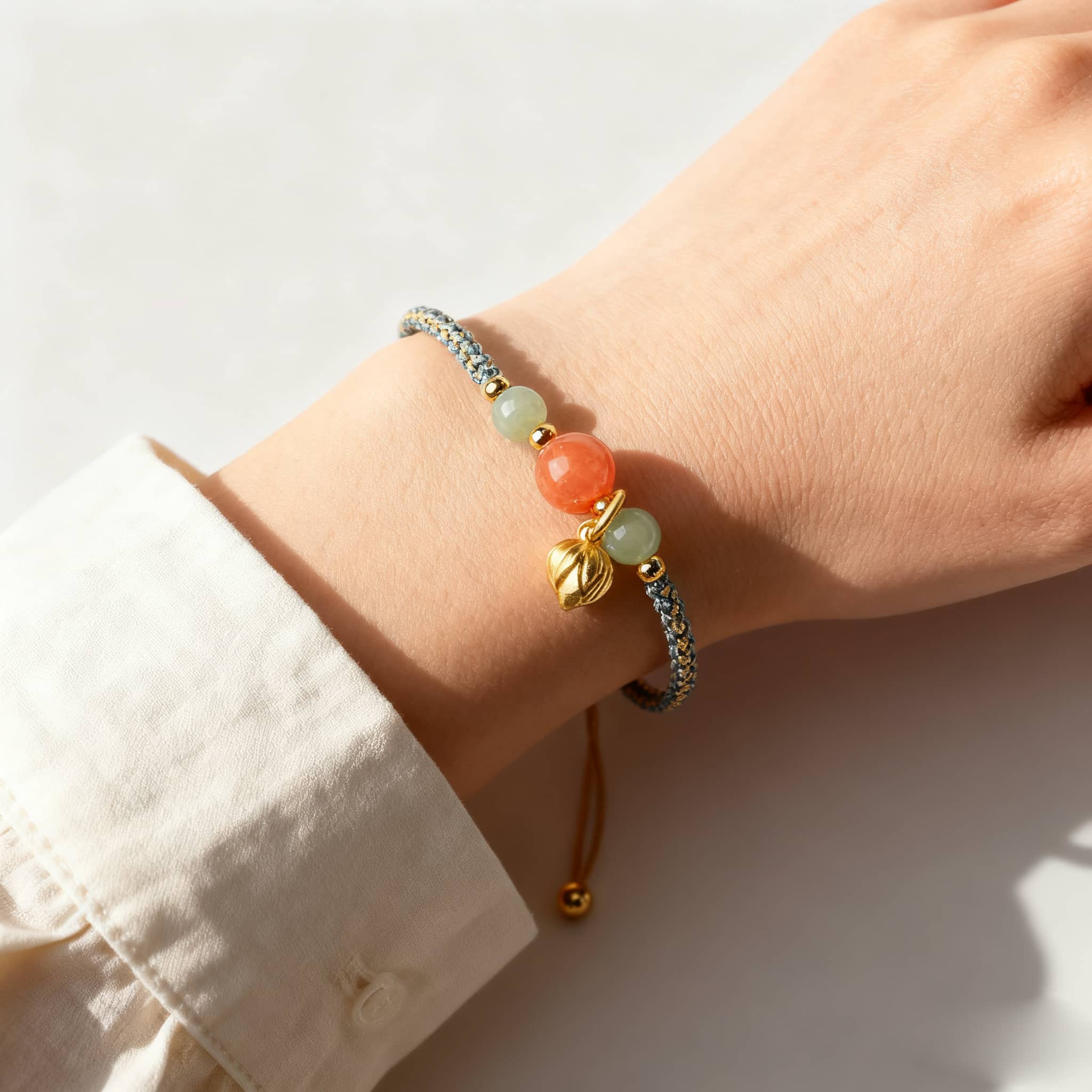 Red chalcedony lotus bracelet with golden charm and adjustable cord, perfect for calming energy
