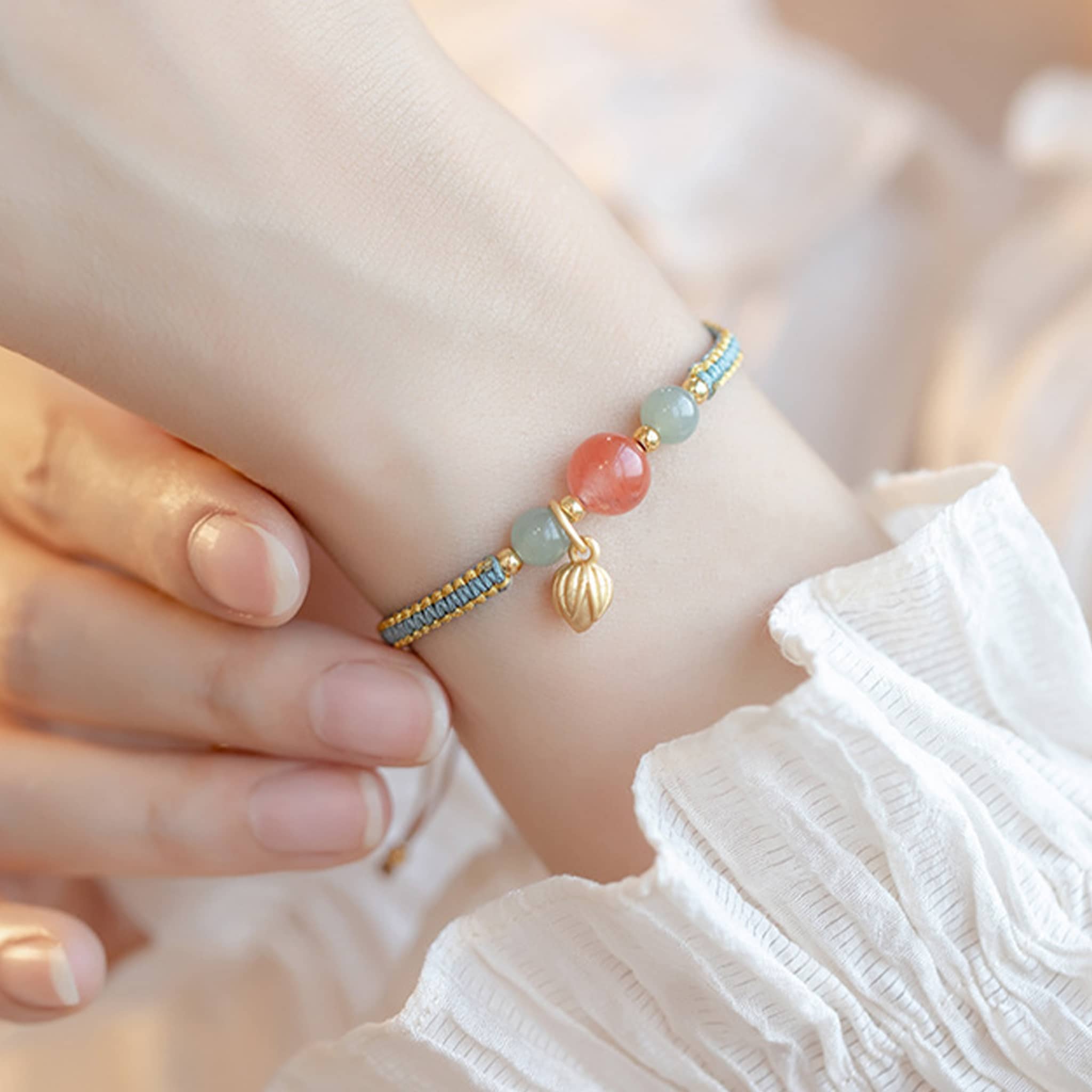 Elegant red chalcedony lotus bracelet with gold leaves and colorful beads on a person's wrist