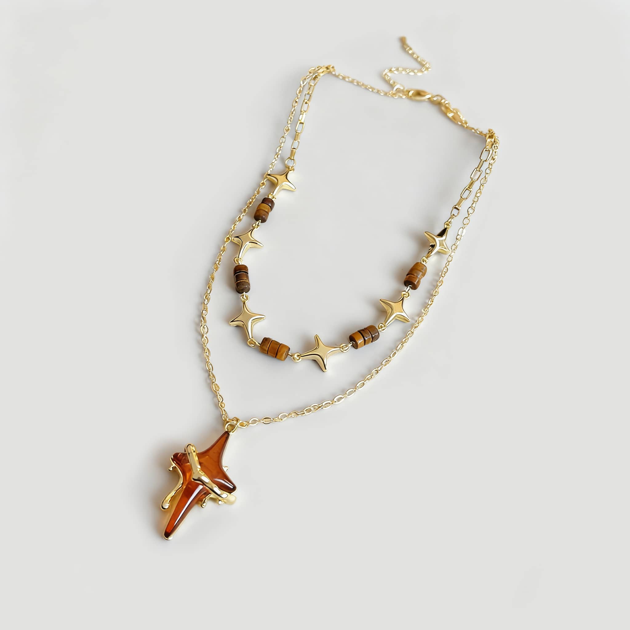 Angry necklace featuring a resin star pendant jewelry with gold chains and bead accents