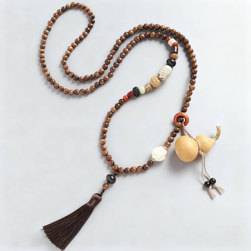 Calm necklace featuring a sandalwood bead cross-body chain with decorative tassel and unique elements