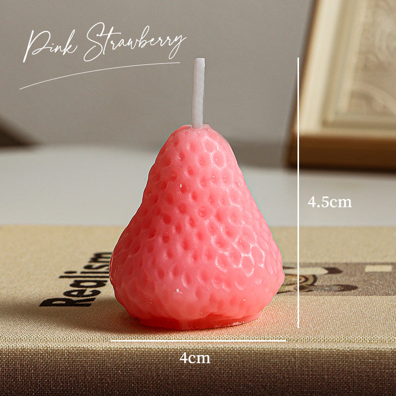 Pink strawberry shaped self-love aromatherapy candle measuring 4.5cm by 4cm on a beige surface