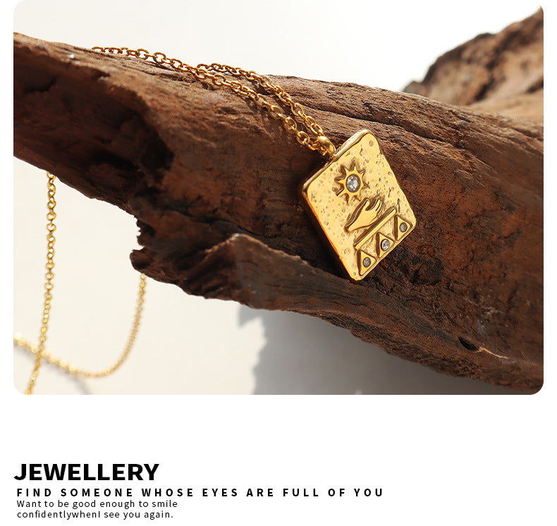 Gold solar guardian pendant necklace with engraved symbols on a rustic wooden background
