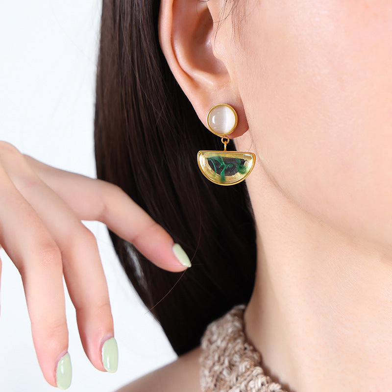 Elegant gold and green insecure statement earrings for confidence worn with knit top