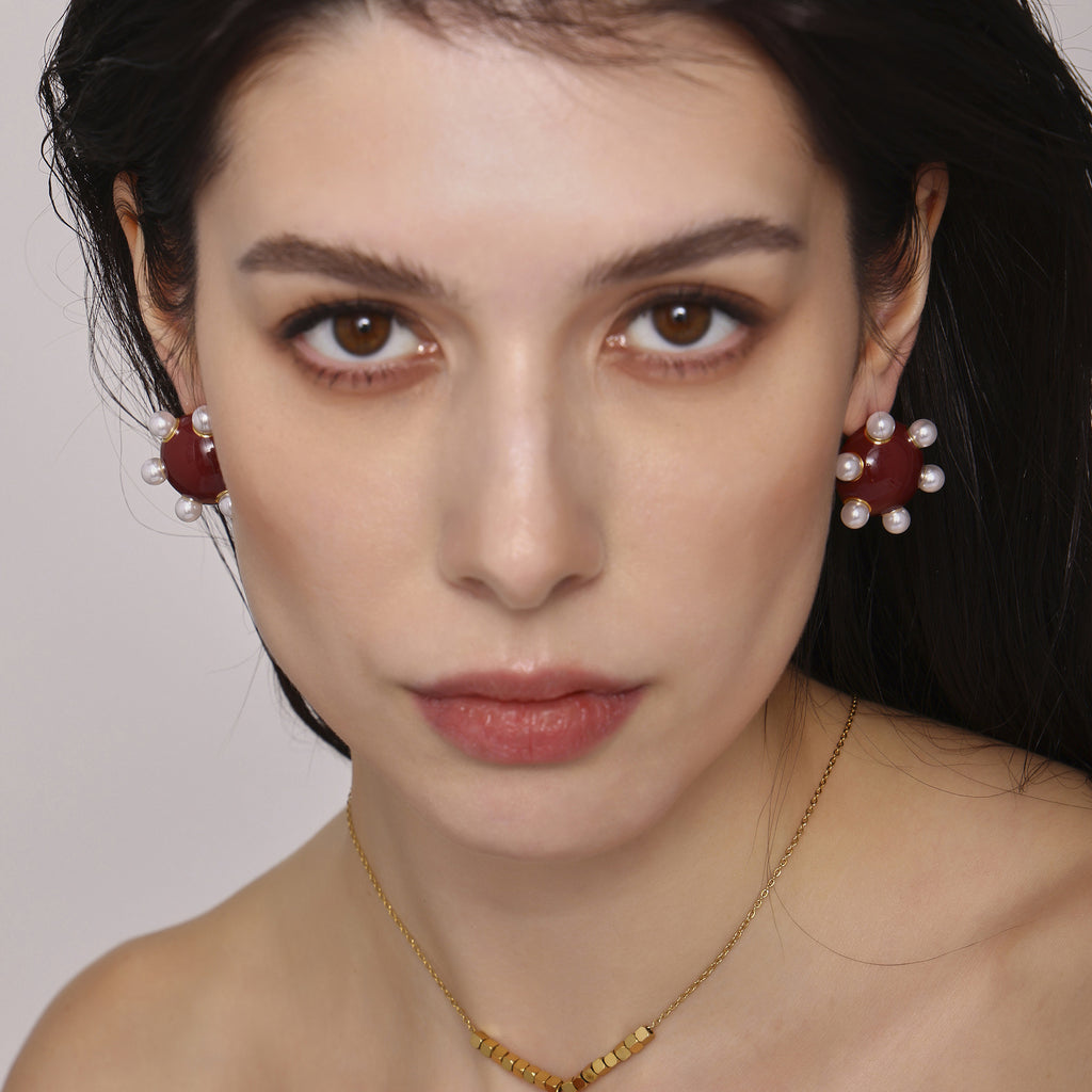 Woman wearing statement gold stud earrings with pearl accents and red center from 我的商店