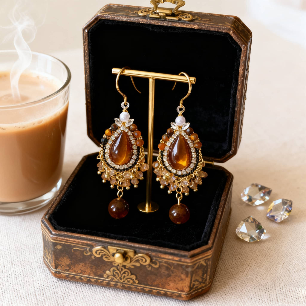 Elegant tiger's eye anxiety relief earrings displayed in a vintage jewelry box beside a cup of coffee