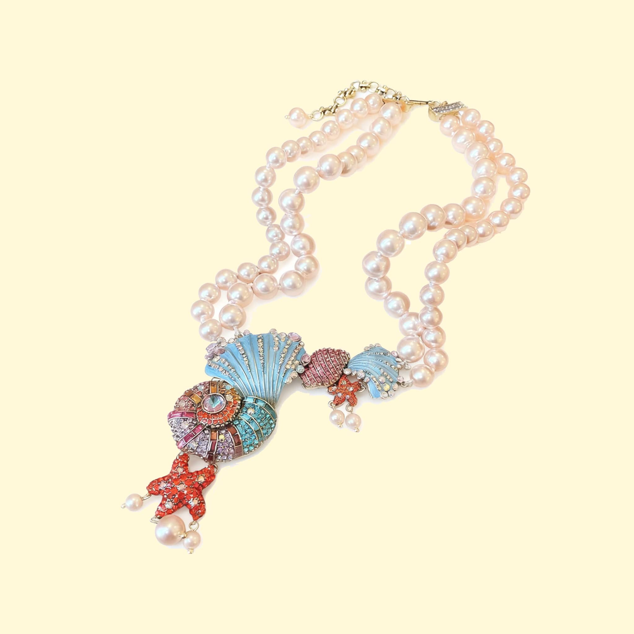 Colorful conch and pearl necklace featuring sea-themed designs and elegant pearl strands
