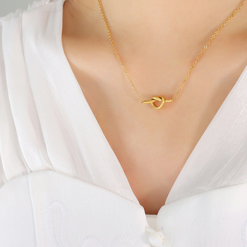 Gold unique heart knot pendant jewelry necklace worn with white blouse