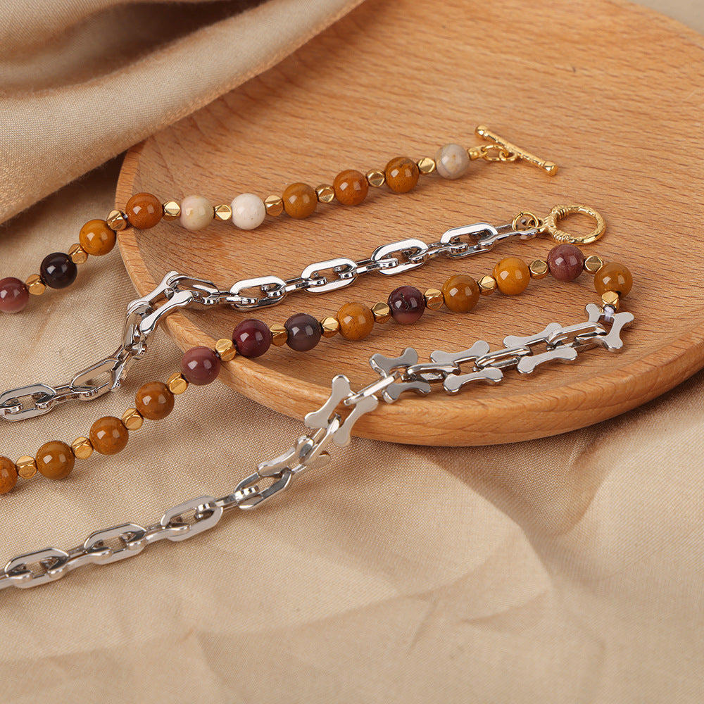Mixed metal bead choker necklace featuring gold and silver chains with colorful beads on wooden display