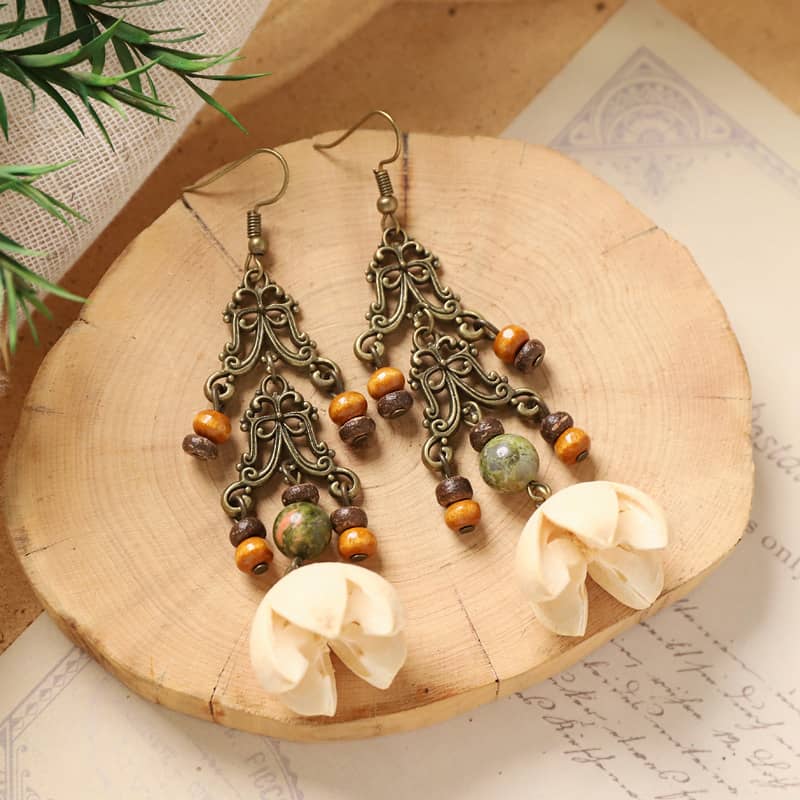 Vintage cut-out metal earrings with decorative beads and floral design, perfect for unique fashion statements.
