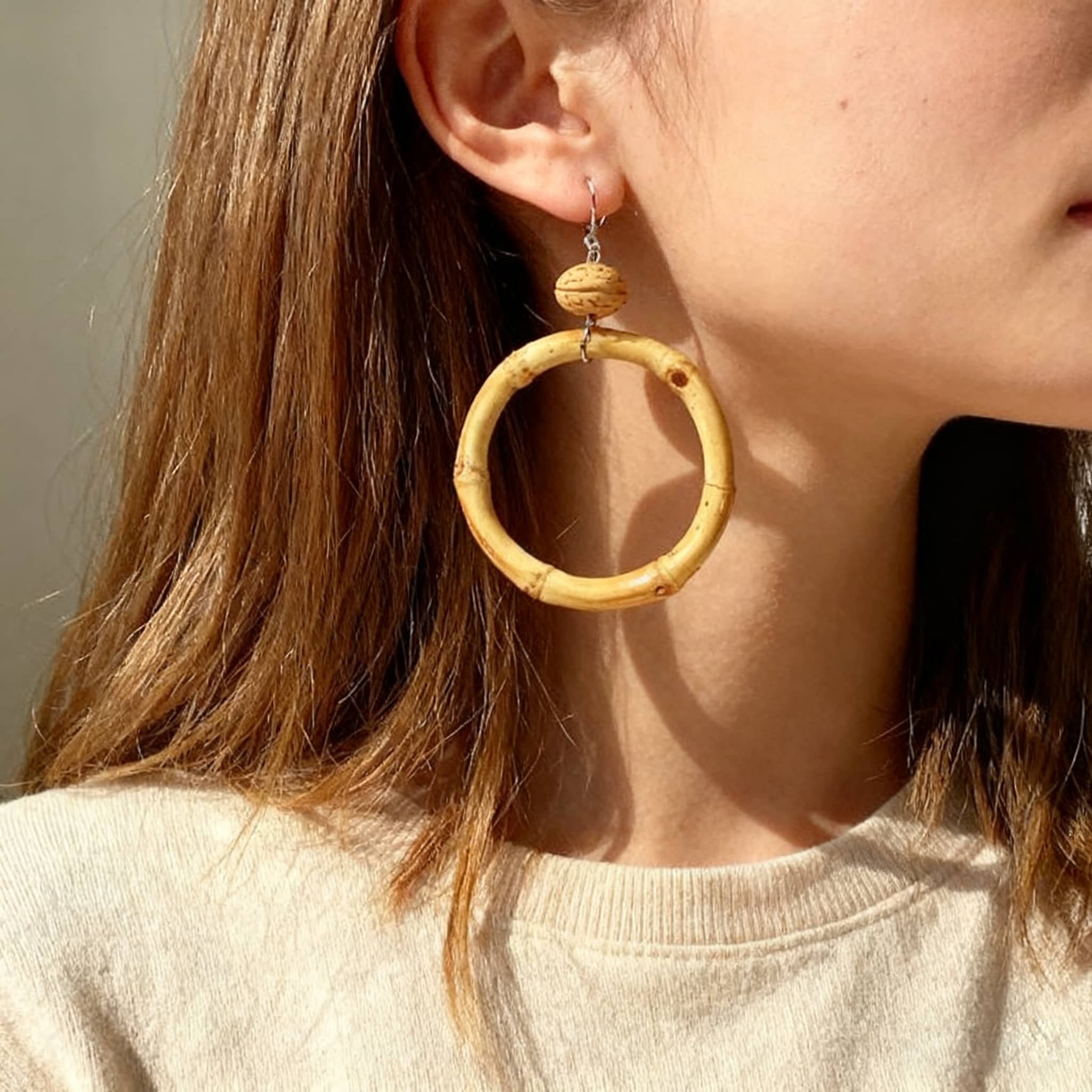 Elegant walnut and bamboo earrings in a circular design worn by a model, perfect for casual style