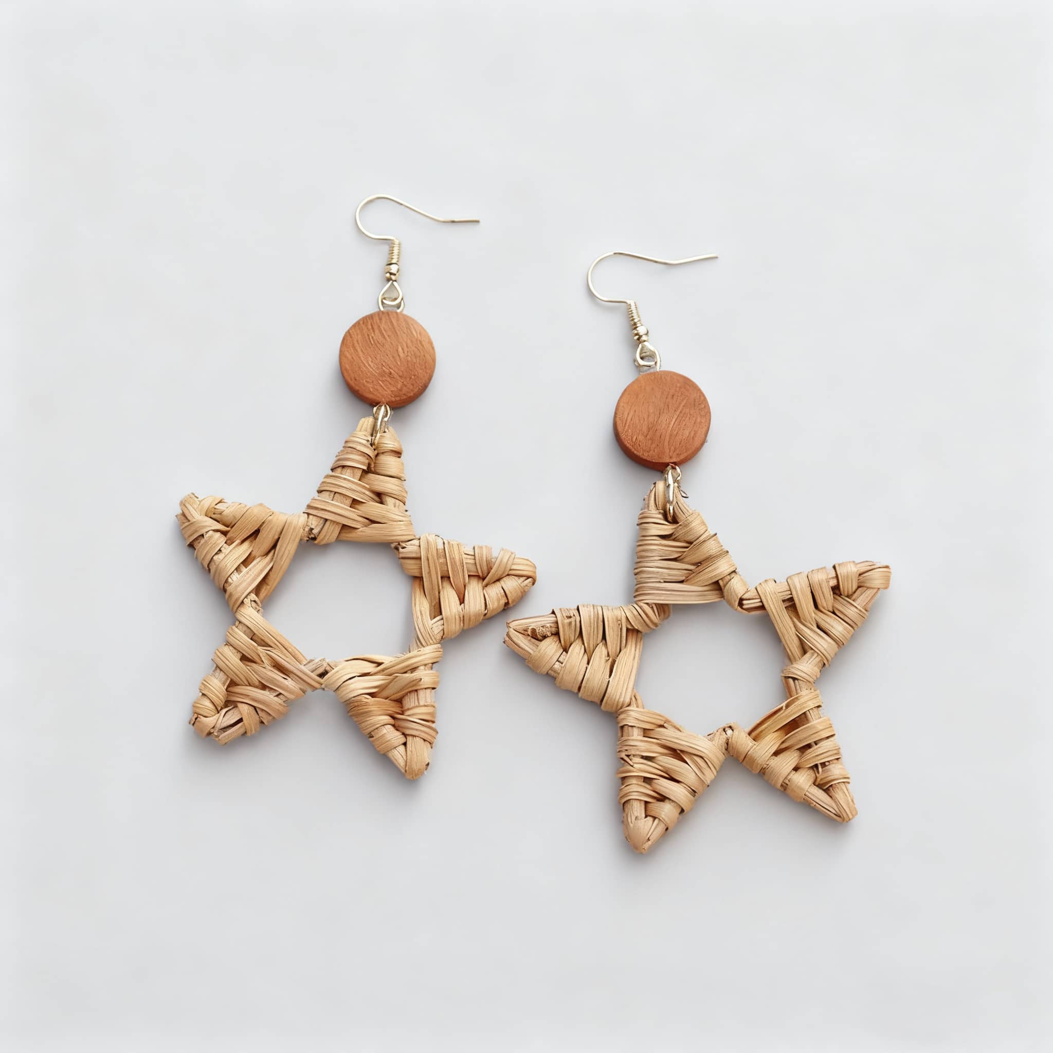 Wood and bamboo star earrings featuring a woven star design and wooden accents