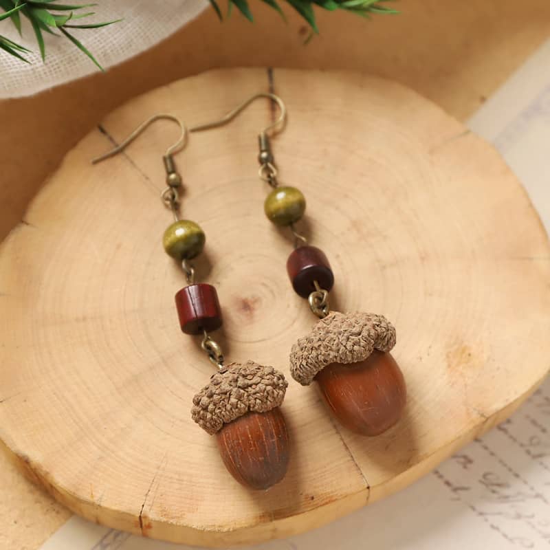 Handcrafted wooden acorn earrings featuring natural tones and unique bead accents