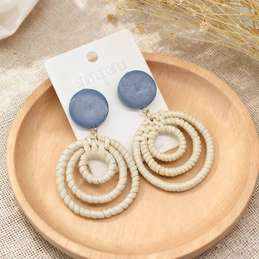 Woven bamboo statement earrings featuring circular designs and blue accents for a stylish look